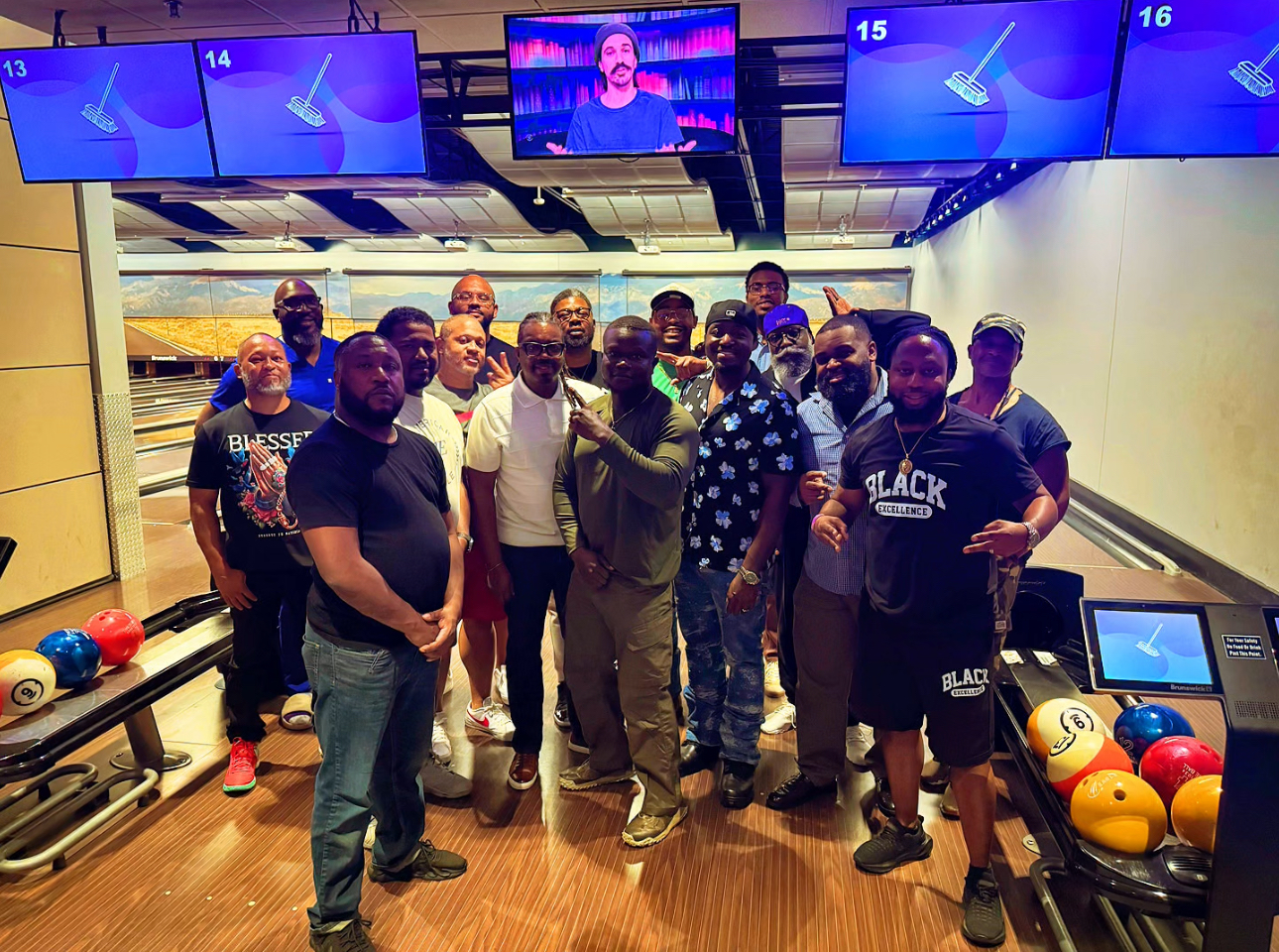A large group of Men Matter brothers posing together for a group photo inside a bowling alley
