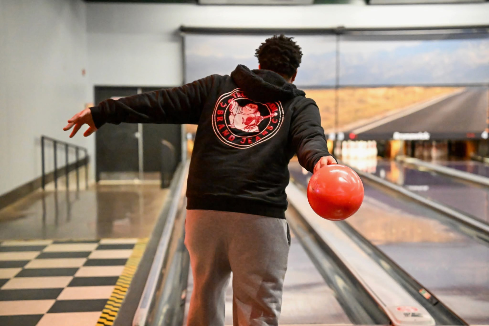 A Men Matter brother releasing a bowling ball down the lane during a men's outing