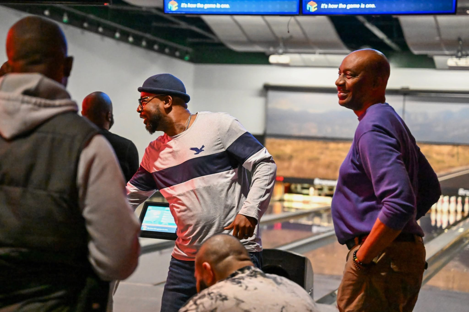 A group of Men Matter brothers talking and joking at the bowling alley